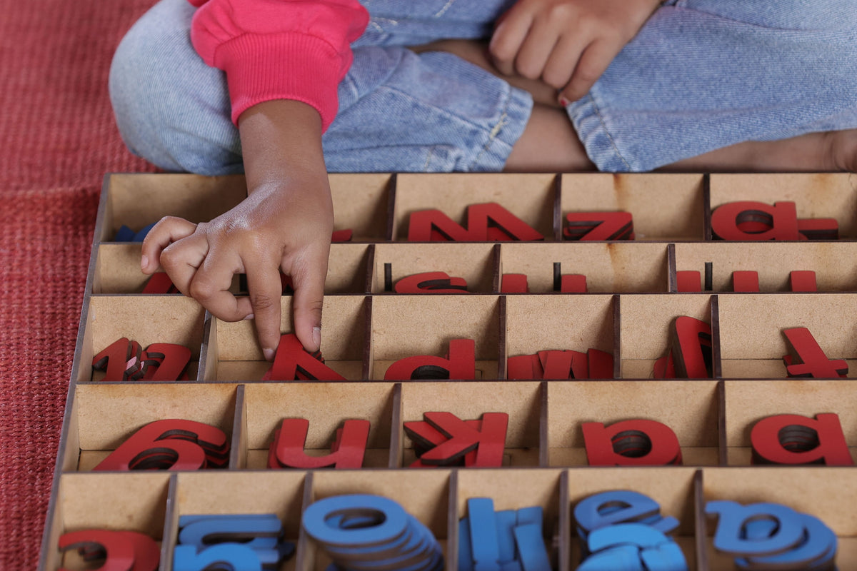 A child learning the alphabet using hands-on wooden letters for education.